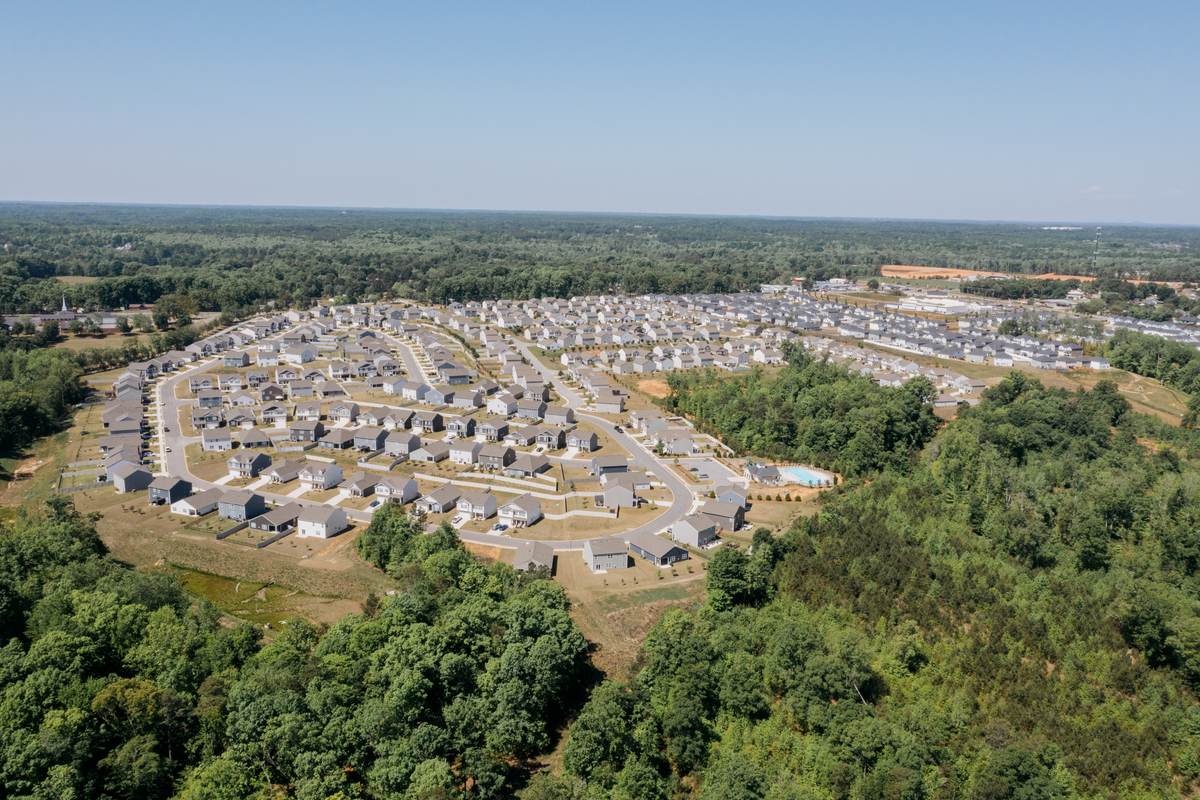 A large subdivision of near-identical houses cut into surrounding woodland in southern Greenville County.