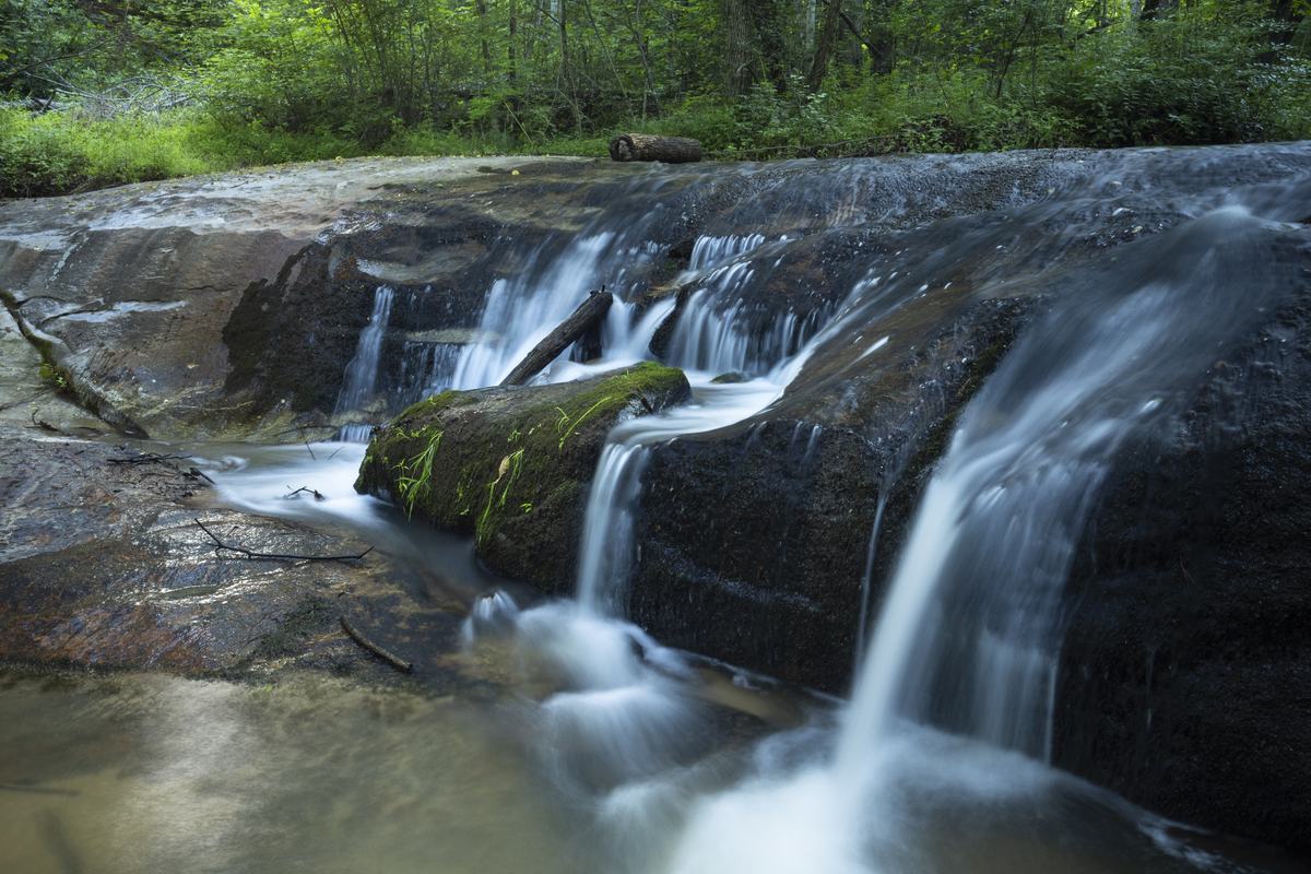 A cascade running over bedrock in the Glassy Mountain foothills, the water blurred by a long exposure.